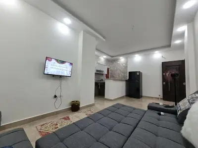 a bedroom with a bed and a flat screen tv at Golden Home in Hurghada