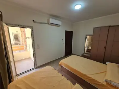 a bedroom with two beds and a large window at Golden Home in Hurghada