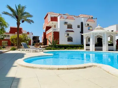 a swimming pool with a gazebo and a building at Hurghada - Magawish Villa 3 in Hurghada