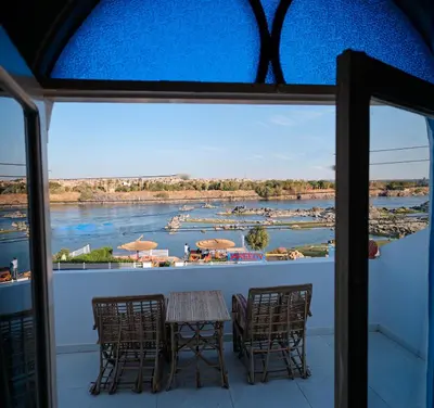 a balcony with a table and chairs and a view of a river at JAREEDY Guest house in Shellal