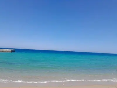 a beach with the ocean and a pier at Hotel apartment with a private beach in Hurghada