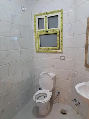 a bathroom with a toilet and a window at Hotel apartment with a private beach in Hurghada