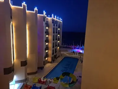 a swimming pool on the side of a building at night at Hotel apartment with a private beach in Hurghada
