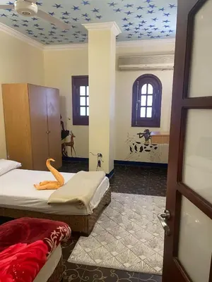 a bedroom with two beds and a room with a door at Eye of Horus House in Luxor