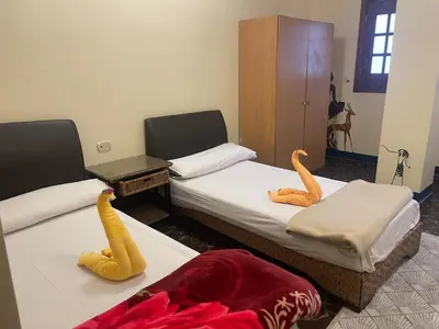 a room with two beds withrenderedrenderedrenderedrenderedrendered at Eye of Horus House in Luxor