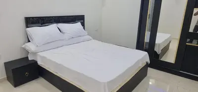 a bed with white sheets and pillows in a room at Colin beach in Hurghada