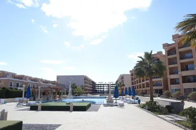 a courtyard with a swimming pool and buildings at Colin beach in Hurghada