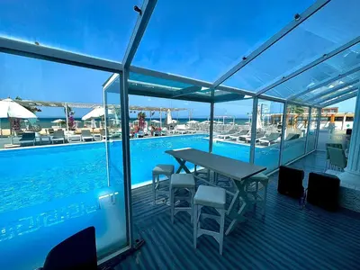 a deck with a table and chairs next to a swimming pool at Hurghada celina branch & resort in Hurghada