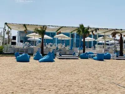 a beach with blue and white chairs and umbrellas at Hurghada celina branch & resort in Hurghada