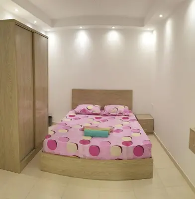 a bedroom with a large pink bed with polka dots at Florenza khamsin Apartment in Hurghada