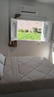 a bedroom with a large bed with a window at Sharqotel Luxor in Luxor