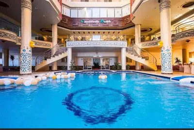 a large swimming pool in a building with stairs at sea front apartment in Hurghada