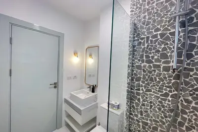 a bathroom with a sink and a mirror at Lofty & Lavish 3 BDR Swan Lake El Gouna in Hurghada