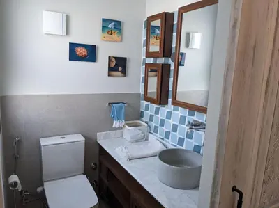 a bathroom with a sink and a toilet and a mirror at Modern Beachfront 1BR Loft with Garden in Somabay in Hurghada