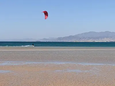 a person is flying a kite on the beach at Somabay 2BR Grand Cabana Minutes From Pool & Sea in Hurghada