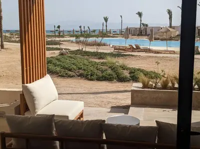 a living room with a couch and a view of a beach at Somabay 2BR Grand Cabana Minutes From Pool & Sea in Hurghada