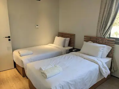 a bedroom with two beds with white sheets and a window at Somabay 2BR Grand Cabana Minutes From Pool & Sea in Hurghada
