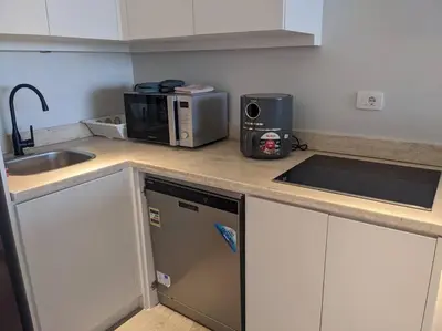 a kitchen counter with a sink and a microwave at Somabay 2BR Grand Cabana Minutes From Pool & Sea in Hurghada