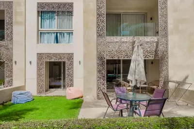 a patio with a table and chairs and a building at Scenic Pool Front 1 BDR Mangroovy Free Pool & Beach in Hurghada
