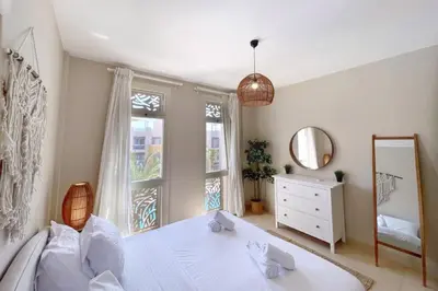 a bedroom with a white bed and a mirror at Embellished 2BDR Penthouse Mangroovy Free Pool & Beach in Hurghada