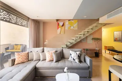 a living room with a couch and a staircase at Vogue & Idyllic 2 BDR Mangroovy Free Pool & Beach Access in Hurghada