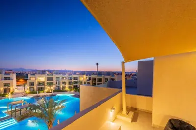 a view from the balcony of a building with a swimming pool at Vogue & Idyllic 2 BDR Mangroovy Free Pool & Beach Access in Hurghada
