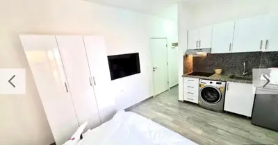 a kitchen with white cabinets and a washing machine at Imperial Beach Resort in Hurghada