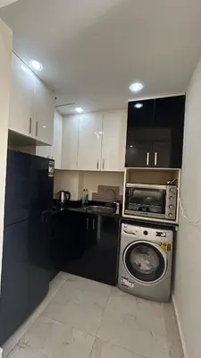 a kitchen with a washing machine and a microwave at hotel mirage aqua park in Hurghada