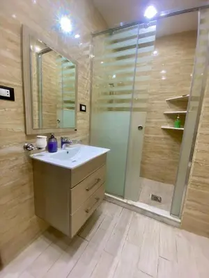 a bathroom with a sink and a shower at Appartement avec rooftop au cœur de Louxor vue sur le Nil in Jazīrat al ‘Awwāmīyah