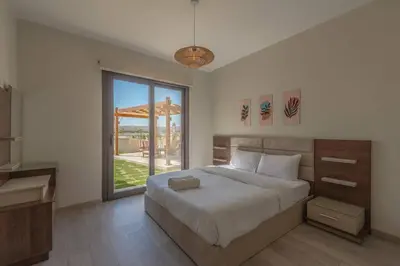 a bedroom with a bed and a large window at Comfy 2BR in Shedwan El Gouna Garden BBQ, Pool, Lagoon in Hurghada