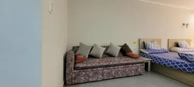 a room with two beds and a couch with pillows at Scandic Resort in Hurghada