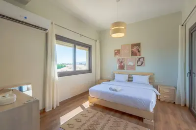a bedroom with a white bed and a window at Charming 2-Lvl 3BR Lagoon Home in Shedwan El Gouna, Pool Access in Hurghada