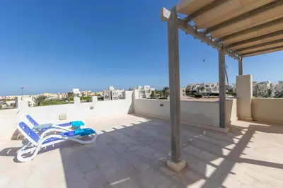 a lounge chair on the roof of a house at Beautiful apartment with roof terrace in Joubal in Hurghada