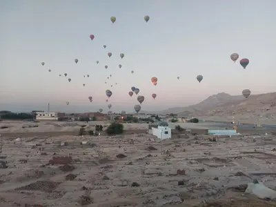 a bunch of hot air balloons flying in the sky at Carter Guesthouse Luxor 2 in ‘Ezbet Abu Ḥabashi
