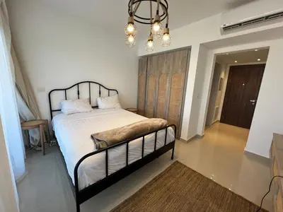 a bedroom with a bed and a chandelier at Studio El Gouna G Cribs Hotel in Hurghada