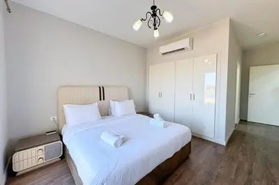 a bedroom with a large white bed with white pillows at Cordial 2 BDR w Pool Access Cyan El Gouna in Hurghada