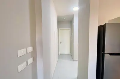a hallway with a black refrigerator in a room at Cordial 2 BDR w Pool Access Cyan El Gouna in Hurghada