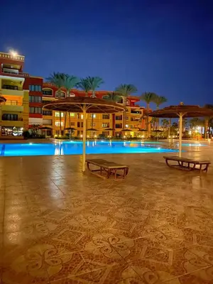 a resort with a swimming pool at night at Esplanada hotel Apartments in Hurghada