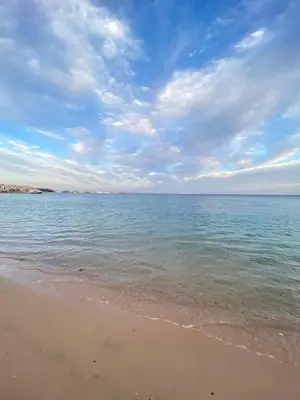 a beach with the ocean and a cloudy sky at Esplanada hotel Apartments in Hurghada