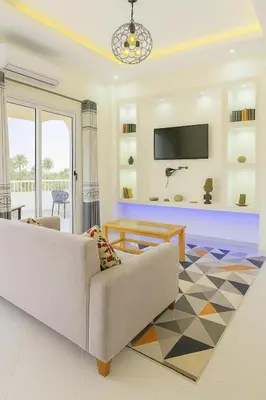 a living room with a couch and a tv at LUXOR DREAM - Panoramic Villa in Luxor