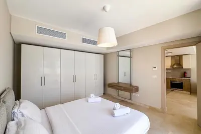 a bedroom with a white bed with towels on it at Stellar 1BDR Mangroovy Free Pool & Beach Access in Hurghada
