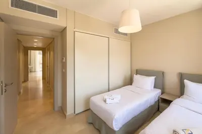 a hotel room with two beds and a hallway at Soothing & Stilly 2BDR Mangroovy Pool & Beach Access in Hurghada