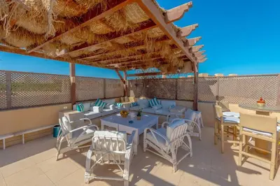 a patio with tables and chairs under a roof at Luxury apartment on the Marina in Hurghada