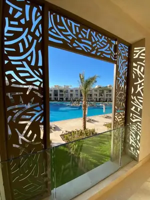 a window view of the swimming pool at a resort at M Residence with Pool View & Beach Access - El Gouna, Hurghada in Hurghada