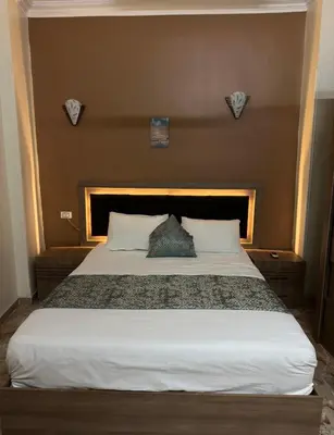 a bedroom with a large bed with a headboard at Luxe Nest Luxor Serviced Apartments 101 in Luxor