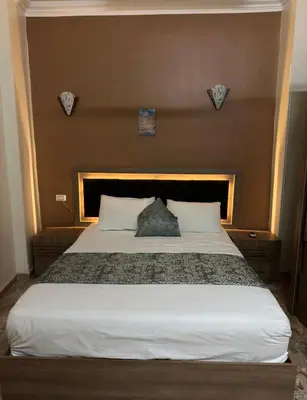 a bedroom with a large bed with a headboard at Luxe Nest Luxor Serviced Apartments 101 in Luxor