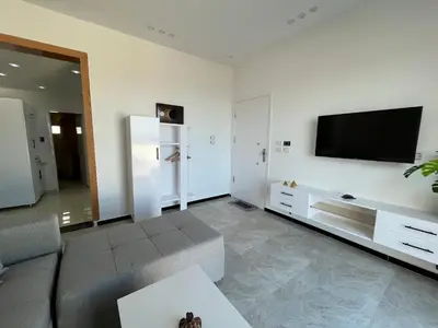 a living room with a couch and a flat screen tv at Kite and Dive Home in Hurghada