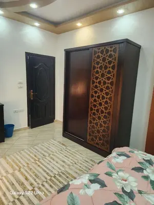 a bedroom with a bed and two wooden doors at Abeer Suites 5 in Hurghada