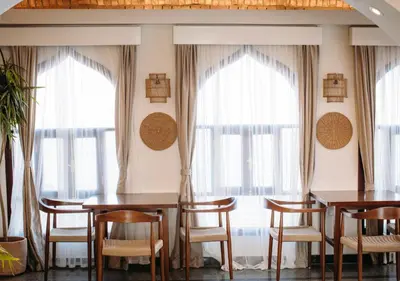 a dining room with tables and chairs and windows at Aro Kato Nubian Guest House in Aswan