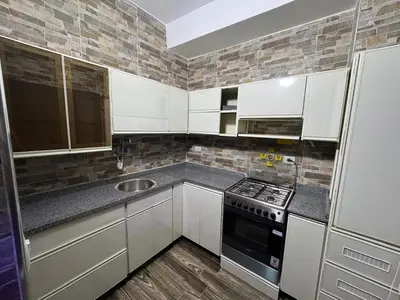 a kitchen with white cabinets and a sink and a stove at BePy's NUBIAN HOUSE in Aswan